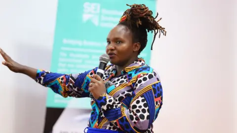 Dr Joyce Kimutai Dr Joyce Kimutai delivers a speech while holding a microphone